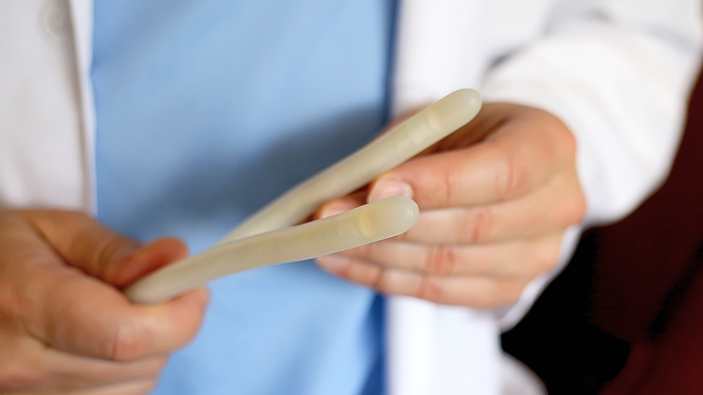 Médico segurando uma prótese peniana maleável, fácil de usar