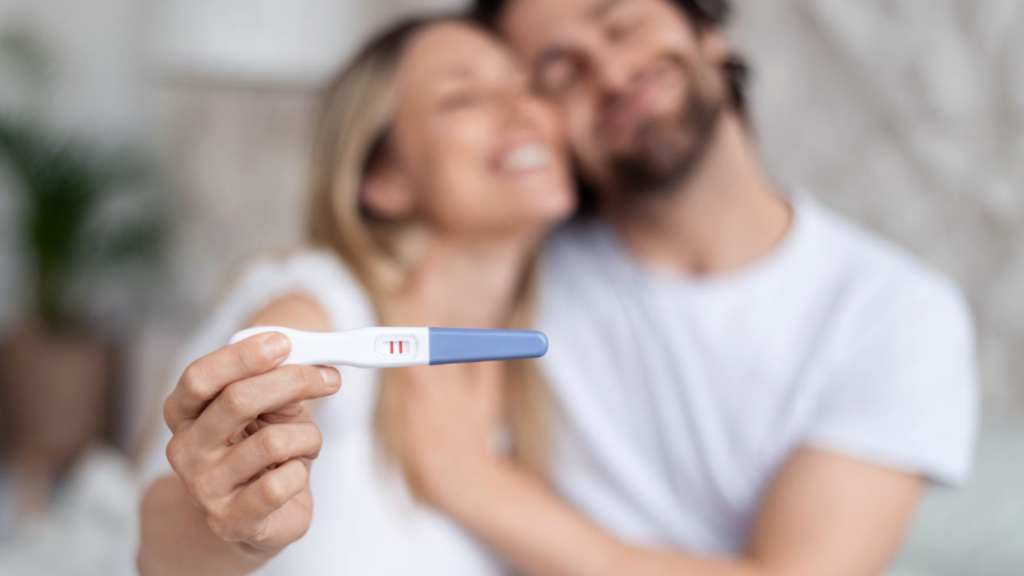 Casal com um teste de gravidez positivo, feliz com a reversão de vasectomia