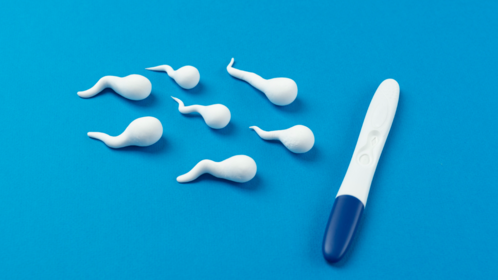 Representação de espermatozoides em fundo azul, caminhando para um teste de gravidez, para falar sobre o homem que sonha em ser pai novamente