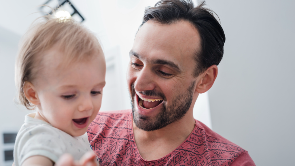 Homem com criança no colo, pronto para ser pai outra vez