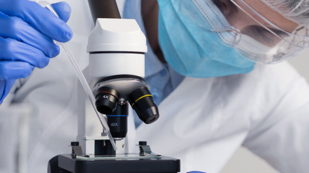Médico no microscópio fazendo biópsia testicular