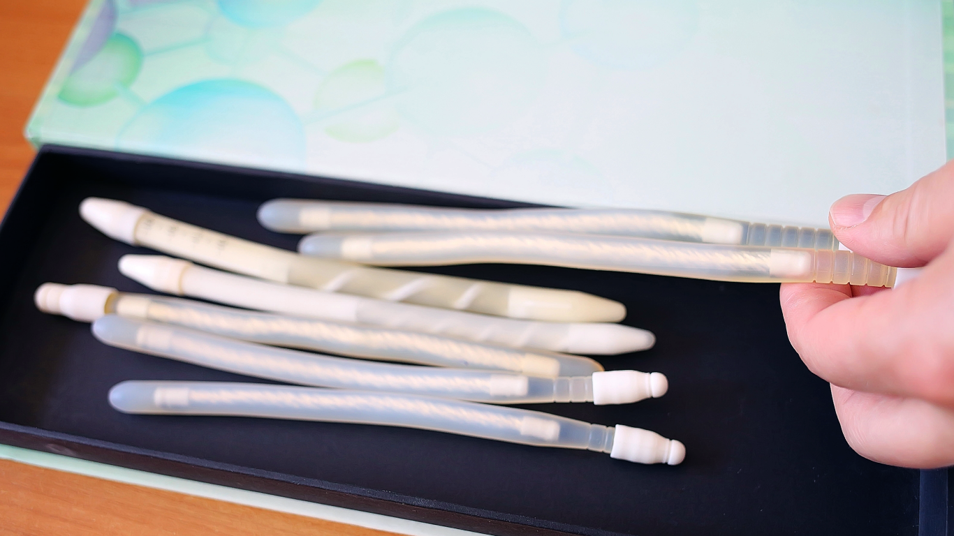 Médico mostrando próteses penianas para o paciente, para falar sobre os tipos inflável e semirrígida